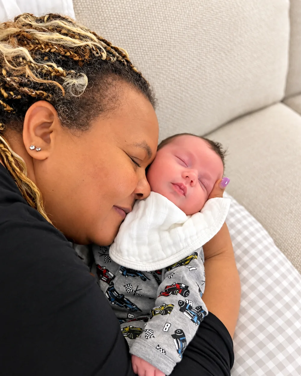 Arlene cuddling a sleeping newborn cheek to cheek
