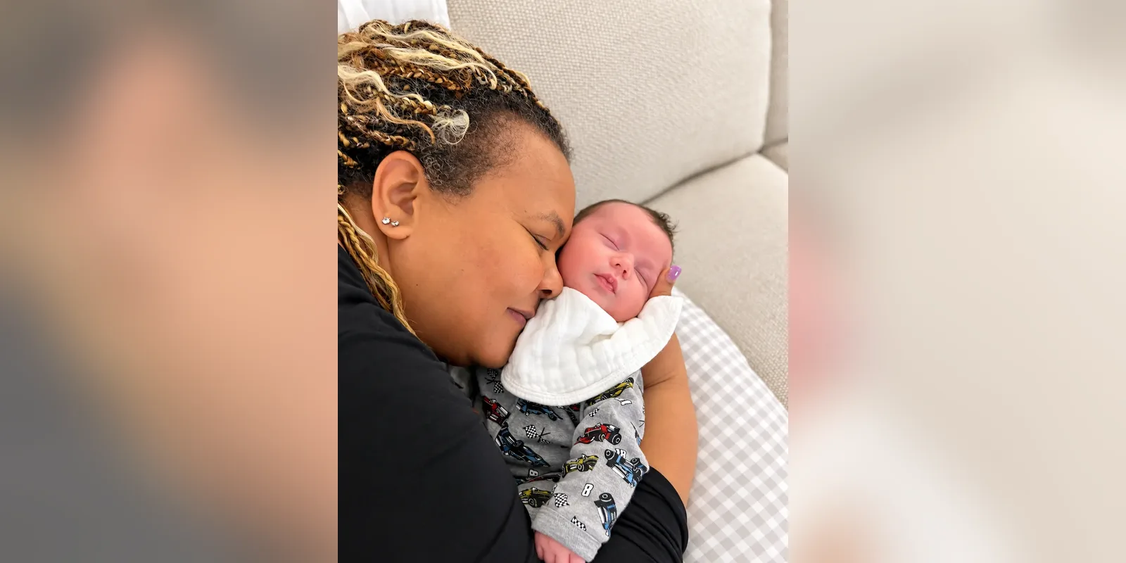 Arlene Excell cuddling a sleeping newborn
