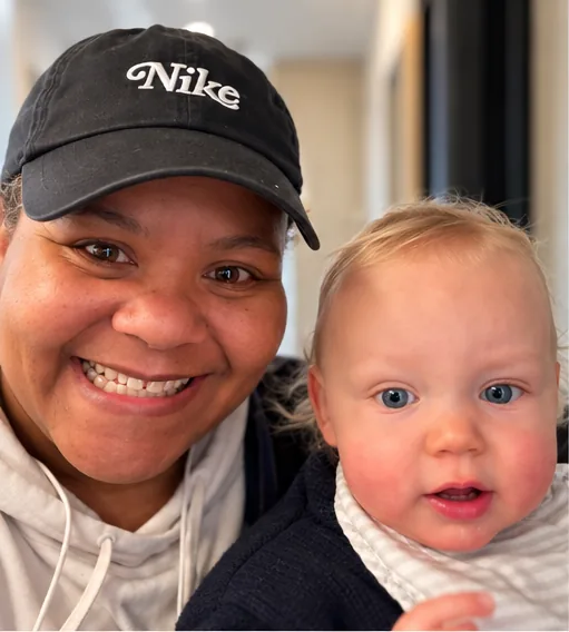 Arlene smiling cheek to cheek with a baby